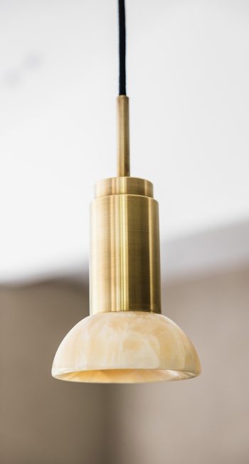 Suspension dorée et en pierre d'Ambre. Idée pensée par le studio d'architecture d'intérieur Studio Naqaa.