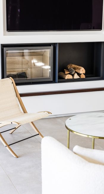 Fauteuil en paille et cheminée. Idée pensée par le studio d'architecture d'intérieur Studio Naqaa.