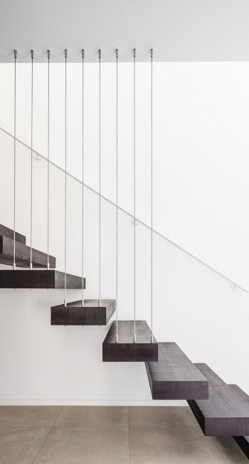 Escalier suspendu par des câbles en acier. Marches en bois. Idée pensée par le studio d'architecture d'intérieur Studio Naqaa.